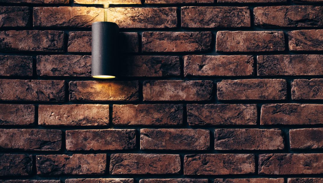 Outdoor lighting highlighting a paver walkway and patio at night