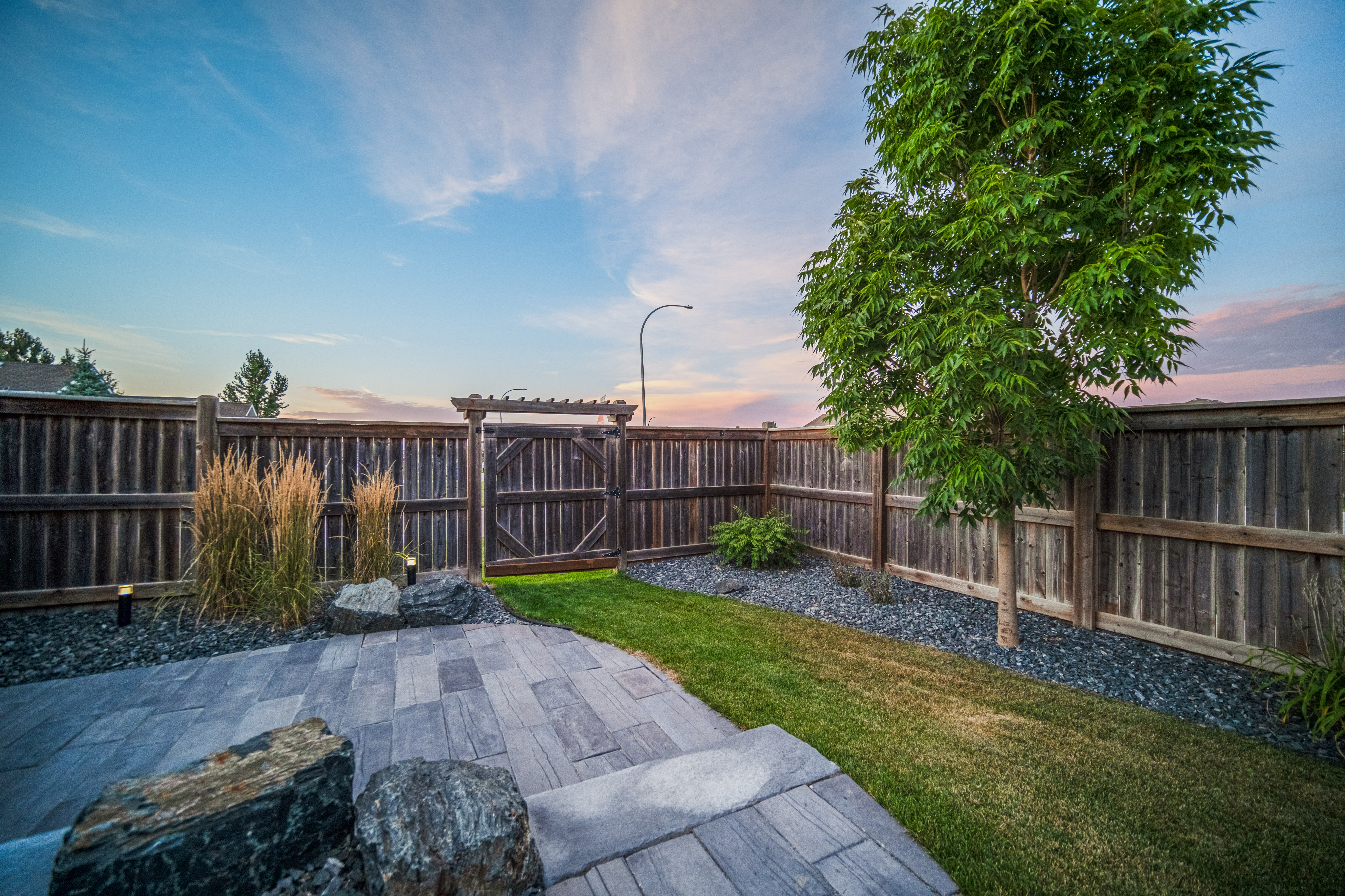 Boulders and stone accents alongside paver hardscape in a Michigan backyard