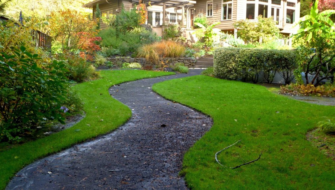 Homeowner planning garden beds alongside a paver walkway in Southeast Michigan